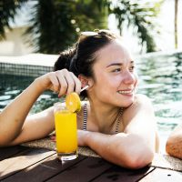 a-woman-in-a-pool-with-an-orange-juice.jpg